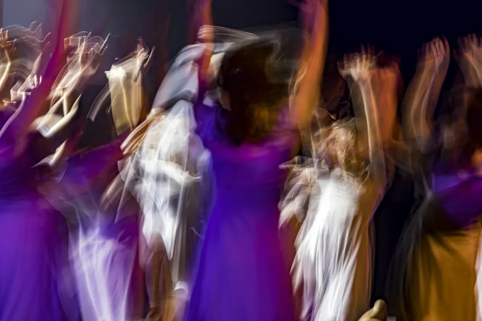 Wedding guests dancing in a joyful blur of purple light on the reception dance floor